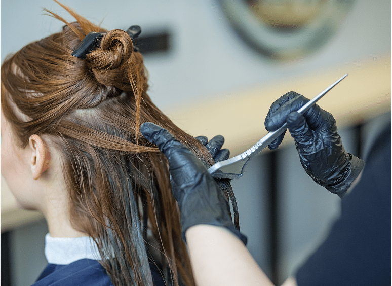 Hairdresser cutting client's hair with scissors.