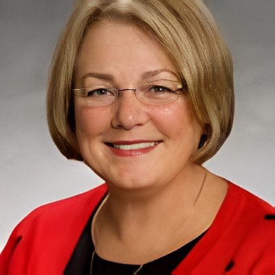 Woman with short blonde hair smiling.