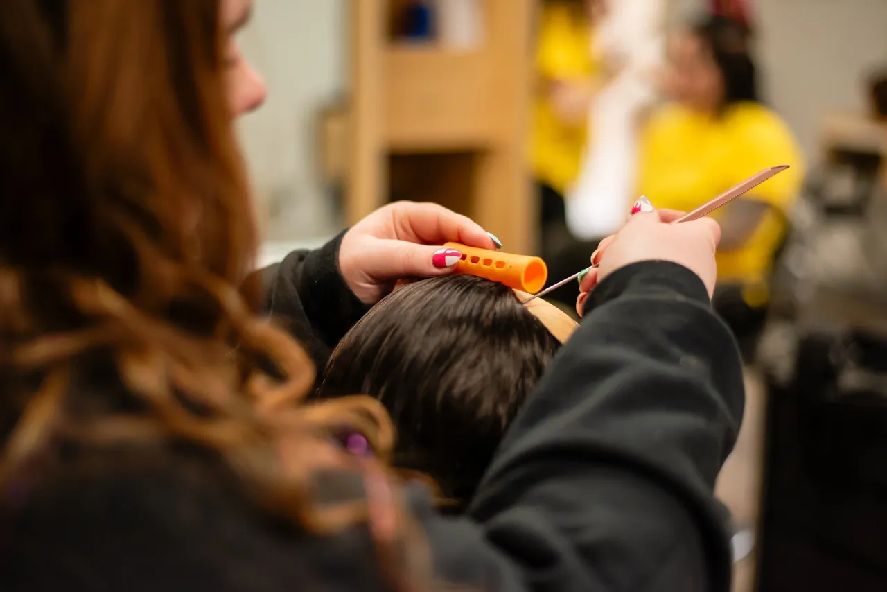 Stylist preparing hair with roller