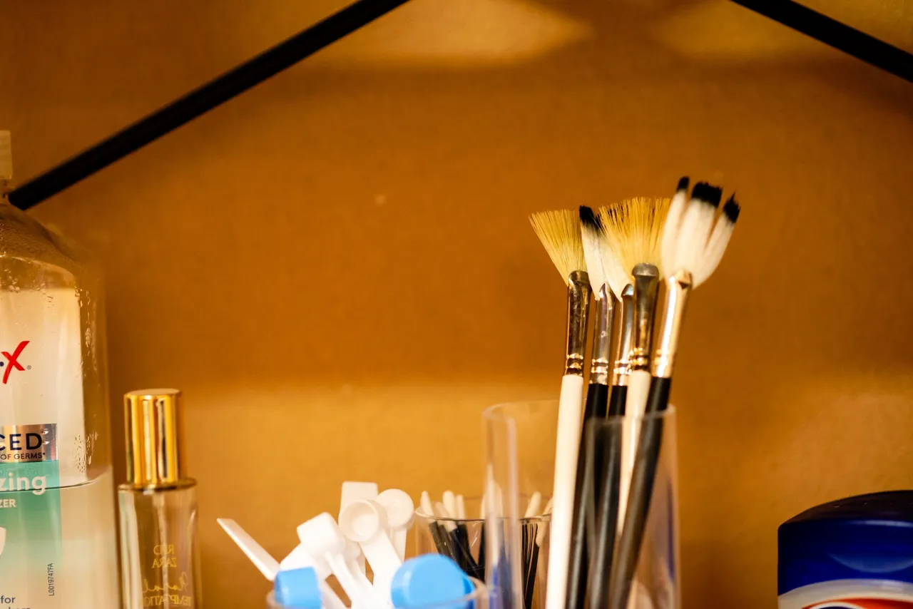 Assorted toiletries and brushes in a cabinet